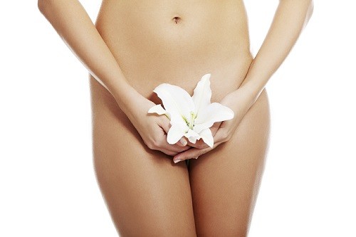 Beautiful nude fit woman body with lily flower, isolated on white